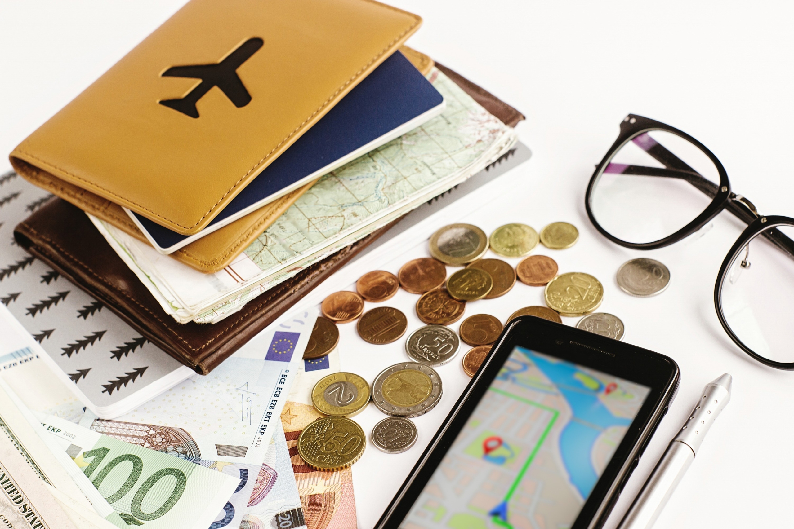money phone passport glasses and map on white background