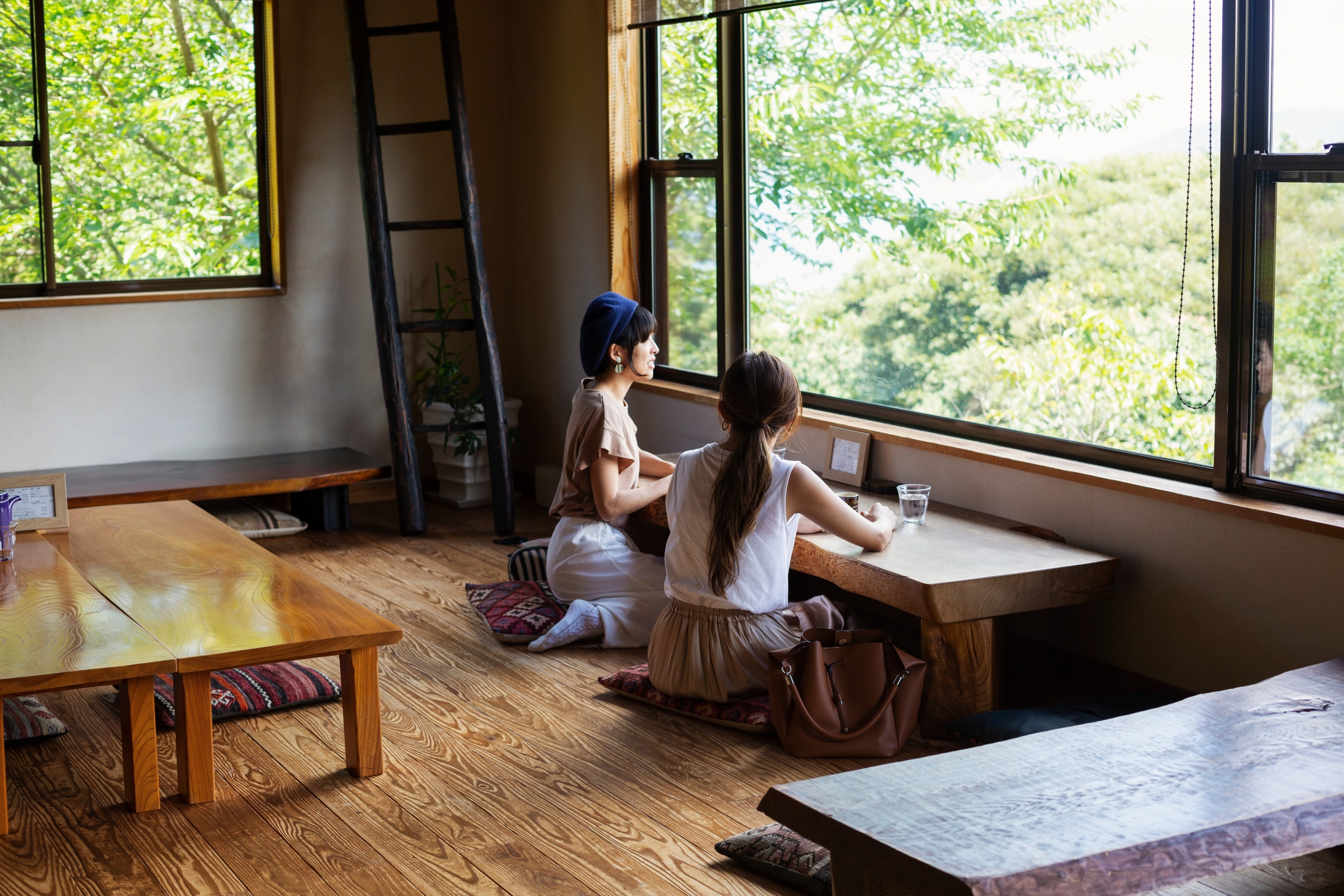 Two Japanese women sitting at a table in a Japanese restaurant, eating.