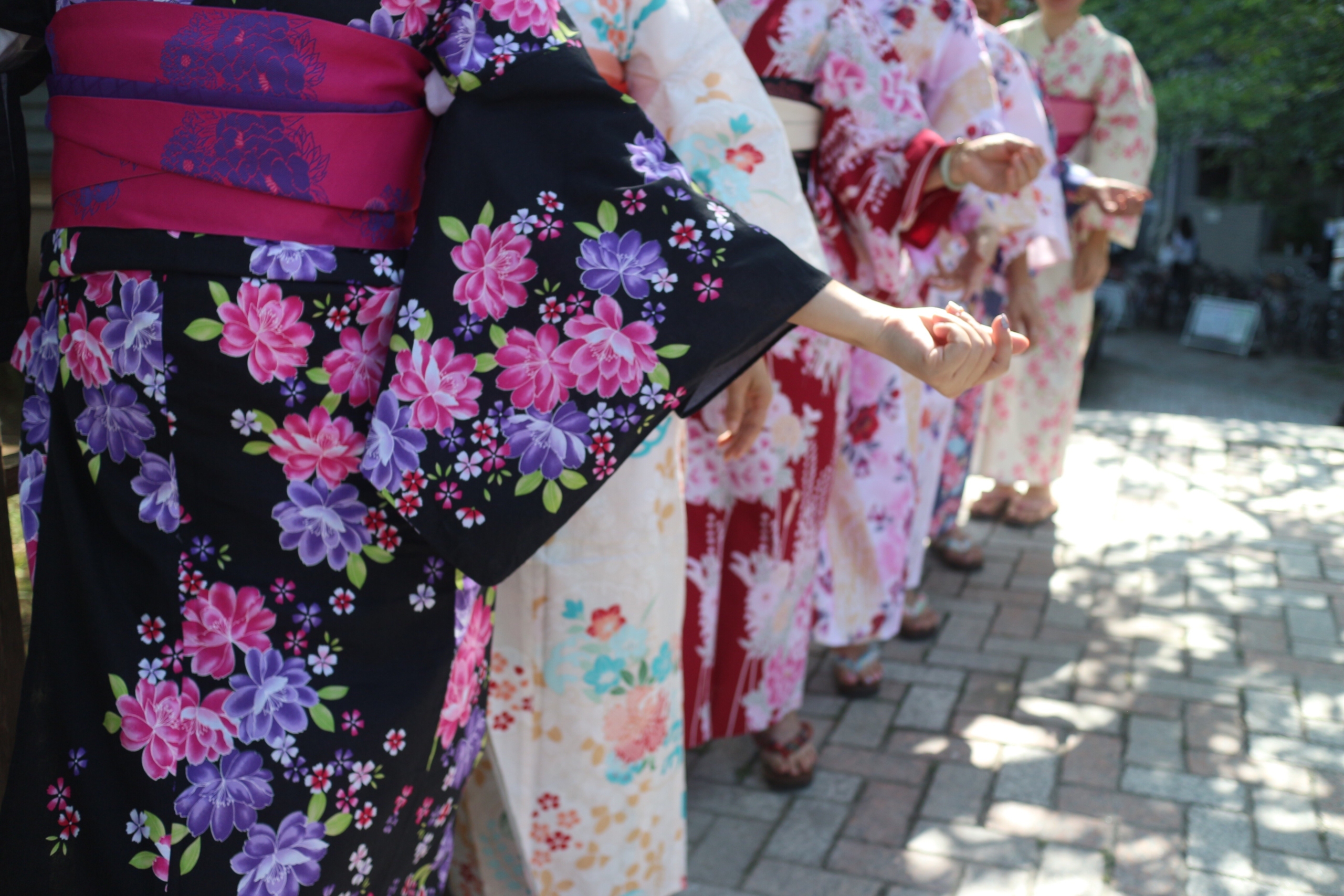 Japanese women wearing colorful floral kimonos lined up
